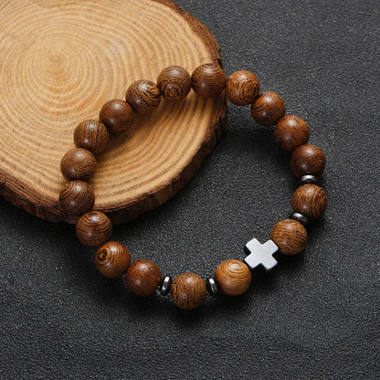 Christian cross wooden bead bracelet on wood slice display