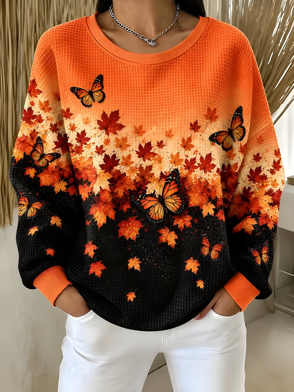 Women's orange and black autumn leaf and butterfly print sweatshirt, front view