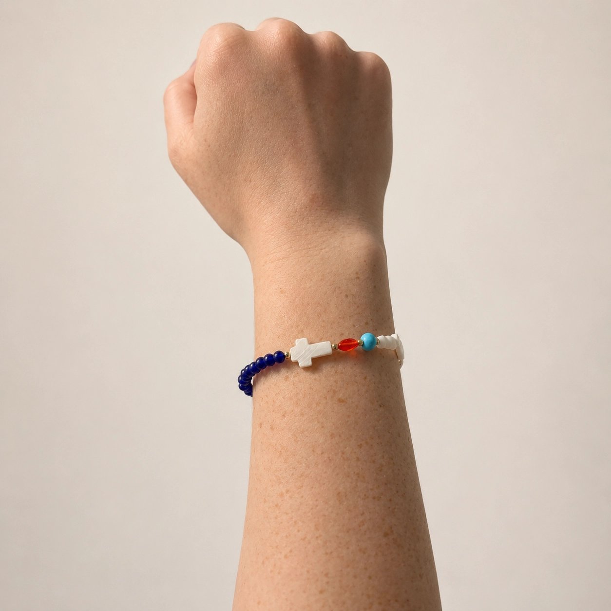 Handmade Story of Jesus bracelet on wrist showing symbolic colored beads and cross