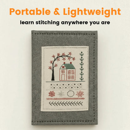 Portable embroidery stitch book with a gray cover and stitched house design