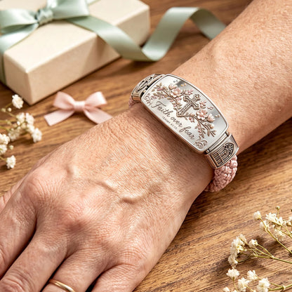 Faith Over Fear Christian bracelet worn on woman's wrist showing elegant braided design and cross centerpiece