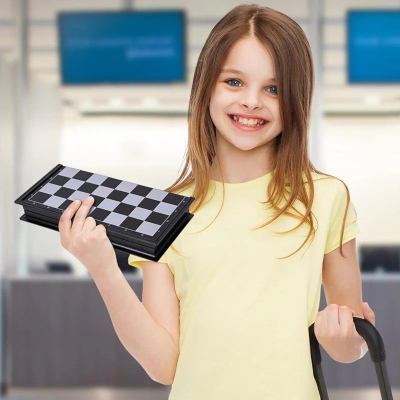 Girl smiling while holding folded portable magnetic chessboard