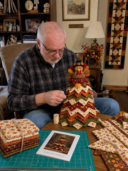 Older man crafting Thanksgiving Harvest quilt tree at cozy home table