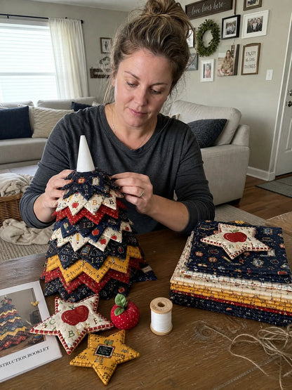 Woman assembling Back-to-School quilt tree with layered star topper