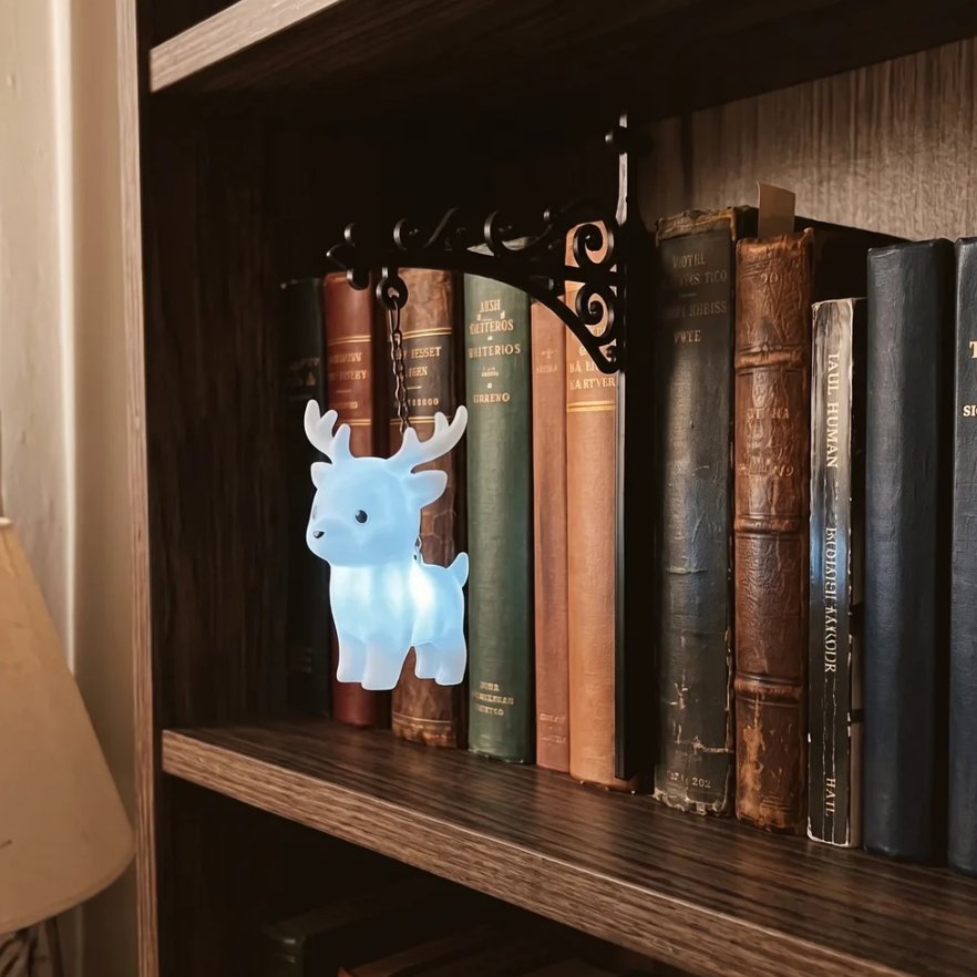 Stag figurine night light glowing blue on bookshelf