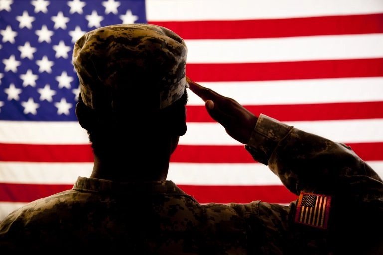 Soldier saluting American flag — patriotic tribute to U.S. military veterans