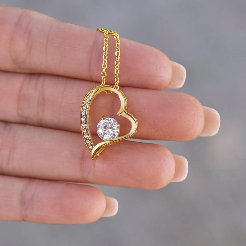 Yellow gold finish daughter heart necklace held in a hand to show pendant detail